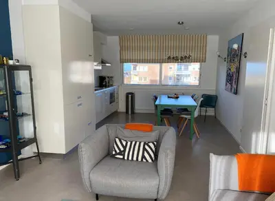 a living room with a chair and a table at Kuifje aan Zee in Egmond aan Zee