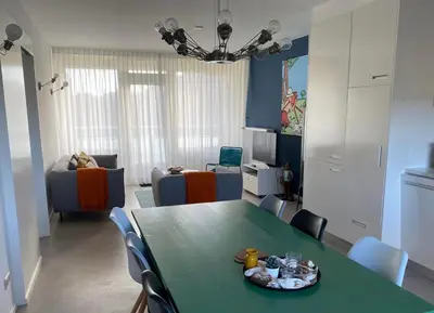 a living room with a green table and chairs at Kuifje aan Zee in Egmond aan Zee