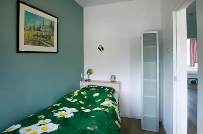 a bedroom with a bed with a green comforter at bij Miep in Egmond aan Zee