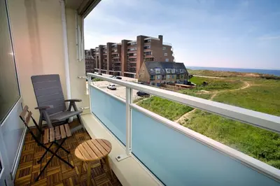 a balcony with a chair and a view of the ocean at bij Miep in Egmond aan Zee