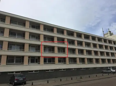 a large building with a red stripe on the side of it at bij Miep in Egmond aan Zee