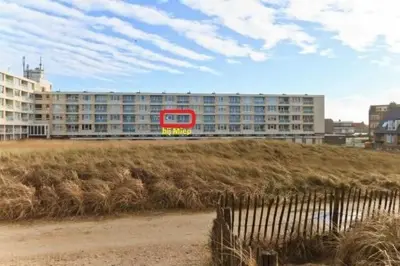 a large building with a red bus in front of it at bij Miep in Egmond aan Zee