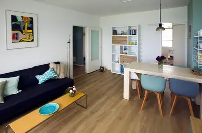 a living room with a blue couch and a table at bij Miep in Egmond aan Zee