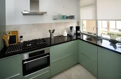 a kitchen with green cabinets and a stove top oven at bij Miep in Egmond aan Zee