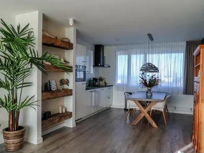 a kitchen and dining room with a table and a plant at de Vuurtoren in Egmond aan Zee