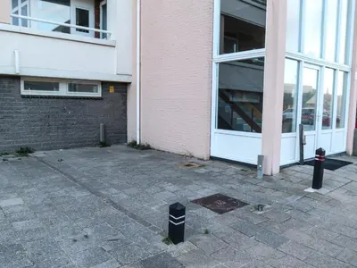 a parking meter in front of a building at de Vuurtoren in Egmond aan Zee