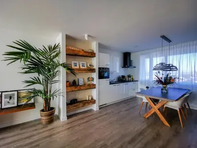 a dining room with a blue table and a plant at de Vuurtoren in Egmond aan Zee