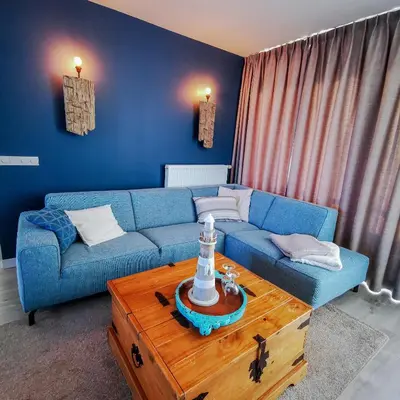 a living room with a blue couch and a coffee table at de Vuurtoren in Egmond aan Zee