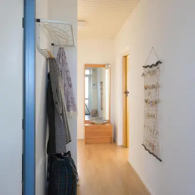 a hallway with a room with a sink and a mirror at de Vloedlijn in Egmond aan Zee