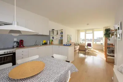 a kitchen and dining room with a table in a kitchen at de Vloedlijn in Egmond aan Zee