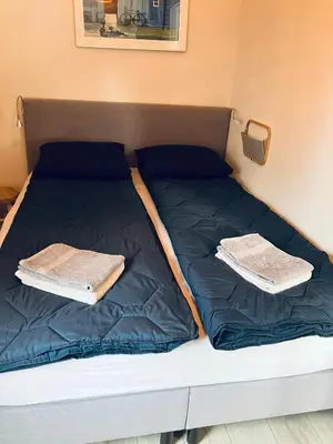 a bed with two towels on top of it at Kings View Cottage, Helemaal vernieuwd 2025 in Warmenhuizen