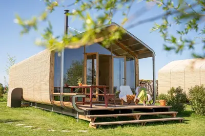 a tiny house on a trailer in the grass at Luxe Wikkelhouse met hottub 'Dompel' in Hoogwoud