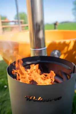 a pot with flames in it on a grill at Luxe Wikkelhouse met hottub 'Dompel' in Hoogwoud