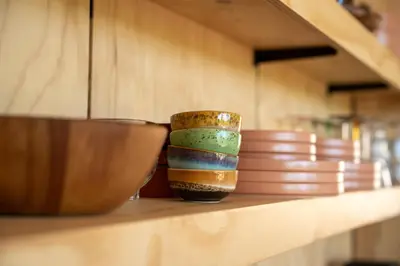 a row of bowls sitting on a shelf at Luxe Wikkelhouse met hottub 'Dompel' in Hoogwoud