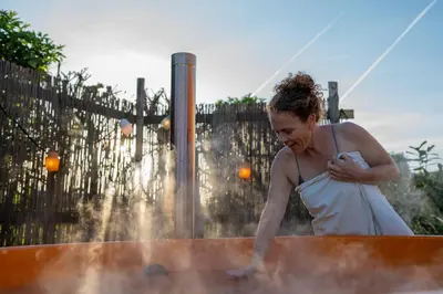 a woman in a white dress standing in a fountain at Luxe Wikkelhouse met hottub 'Dompel' in Hoogwoud