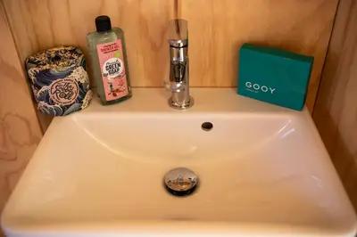 a sink with a bottle of soap and a detergent at Luxe Wikkelhouse met hottub 'Dompel' in Hoogwoud