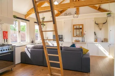 a living room with a couch and a ladder at Pat's home in Alkmaar