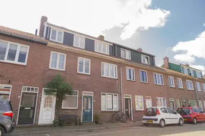 a brick building with cars parked in front of it at Pat's home in Alkmaar
