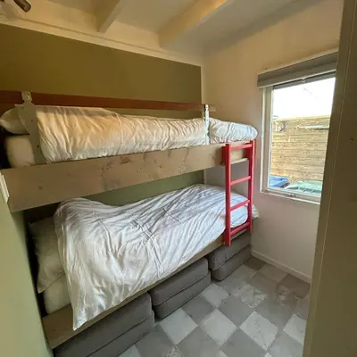 two bunk beds in a small room with a window at Nice chalet near Reeuwijkse plassen in Reeuwijk