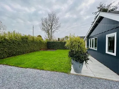 a yard with a large pot of grass next to a house at Nice chalet near Reeuwijkse plassen in Reeuwijk