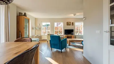 a kitchen and living room with a table and chairs at Klavertje vier in Schoorl