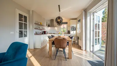 a kitchen and dining room with a table and chairs at Klavertje vier in Schoorl