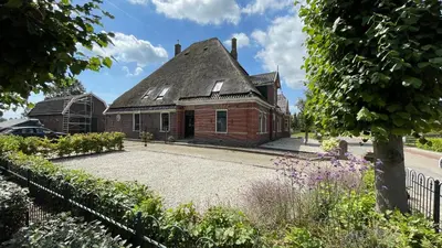 an old brick house with a roof at Het Kerspel in Hoogkarspel