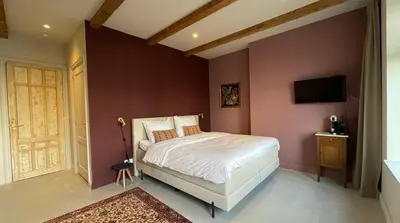 a bedroom with a bed and a tv on a wall at Het Kerspel in Hoogkarspel