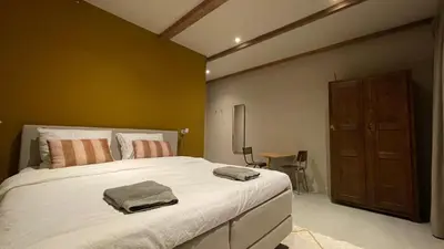 a bedroom with a large white bed and a table at Het Kerspel in Hoogkarspel