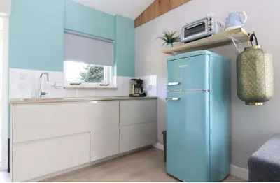 a kitchen with a blue refrigerator and a sink at Rekerlanden 153 in Schoorldam