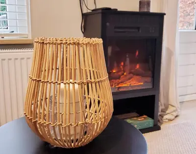 a wicker vase sitting on a table in front of a fireplace at Rekerlanden 153 in Schoorldam