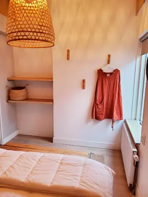 a bedroom with a bed and a hanging shirt at Rekerlanden 153 in Schoorldam