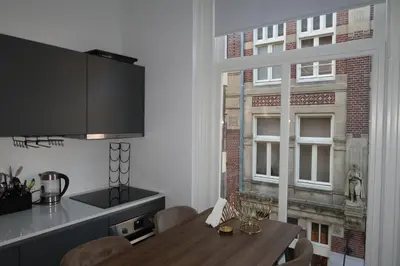 a dining room with a table and a window at Appartement Rokin in Amsterdam