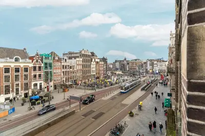 a city with a street with a bus on the road at Appartement Rokin in Amsterdam