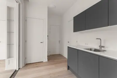 a white kitchen with a sink and a counter at Appartement Rokin in Amsterdam