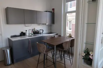 a kitchen with a wooden table and stools at Appartement Rokin in Amsterdam