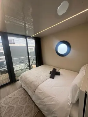 a bedroom with a bed with a black hat on it at Winter escape at houseboat Sanches Lake View Monnickendam in Monnickendam