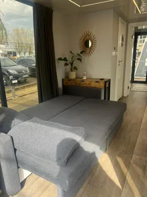 a bedroom with a large bed and a mirror at Winter escape at houseboat Sanches Lake View Monnickendam in Monnickendam