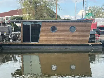a small house on a boat in the water at Winter escape at houseboat Sanches Lake View Monnickendam in Monnickendam