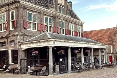 a building with chairs and tables in front of it at Winter escape at houseboat Sanches Lake View Monnickendam in Monnickendam