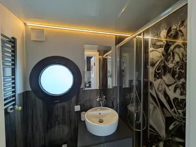 a bathroom with a sink and a round window at Winter escape at houseboat Sanches Lake View Monnickendam in Monnickendam