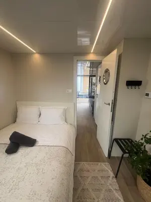 a bedroom with a white bed with a black shoe on it at Winter escape at houseboat Sanches Lake View Monnickendam in Monnickendam