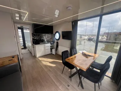 a kitchen and dining room with a table and chairs at Winter escape at houseboat Sanches Lake View Monnickendam in Monnickendam