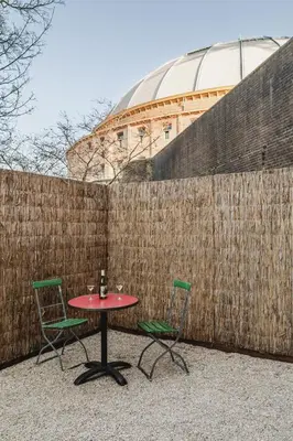 a table and two chairs in front of a fence at Metzlr House in Haarlem