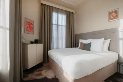 a bedroom with a large white bed and a window at Metzlr House in Haarlem