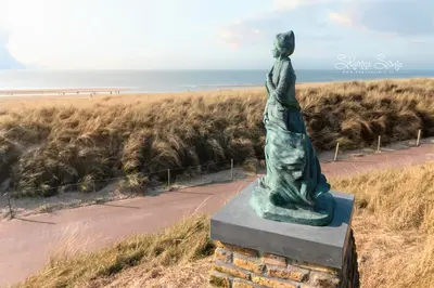 a statue of a woman looking out at the ocean at Lovina Beach House by Urban Home Stay in Egmond aan Zee