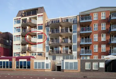 a tall apartment building with a red circle on it at Zonnehoek 71 in Egmond aan Zee