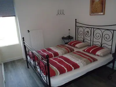 a bed with two red pillows on it in a bedroom at Zonnehoek 71 in Egmond aan Zee