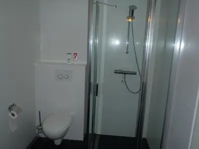a bathroom with a glass shower and a toilet at Zonnehoek 71 in Egmond aan Zee