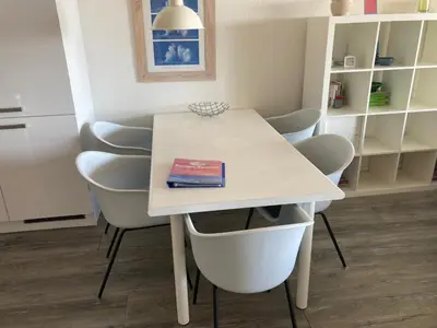 a white table and chairs with a book on it at Zonnehoek 71 in Egmond aan Zee